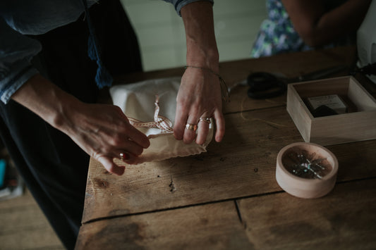 Two hands tying a draw strong bag closed