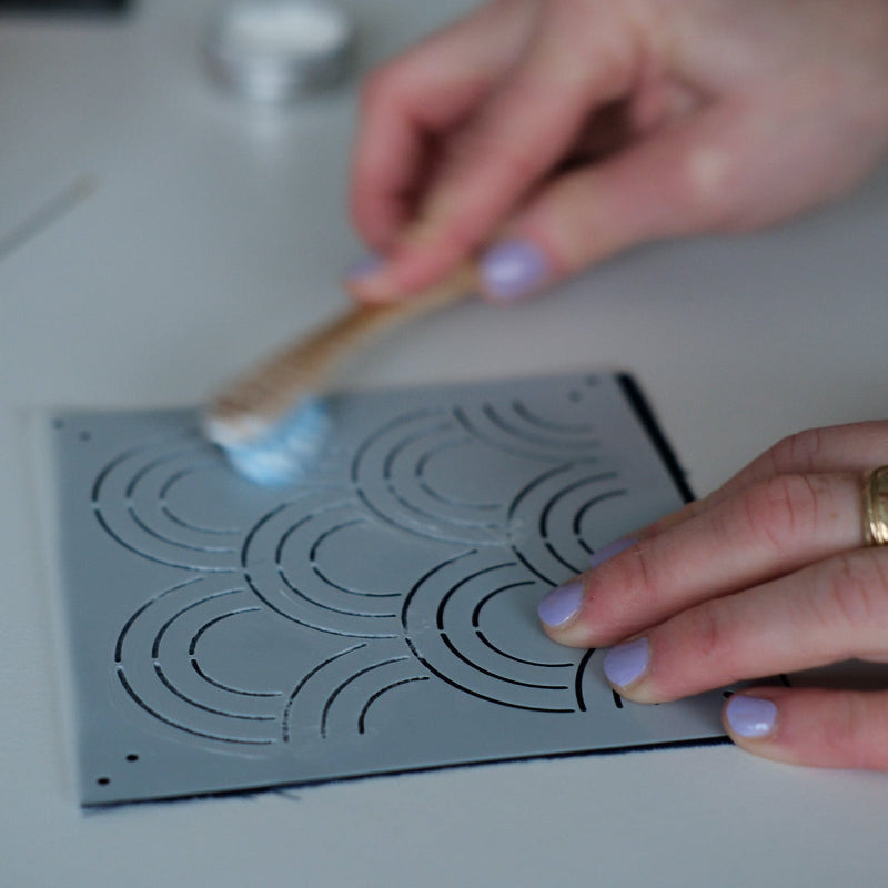 Person applying chalk to a plastic sashiko stencil