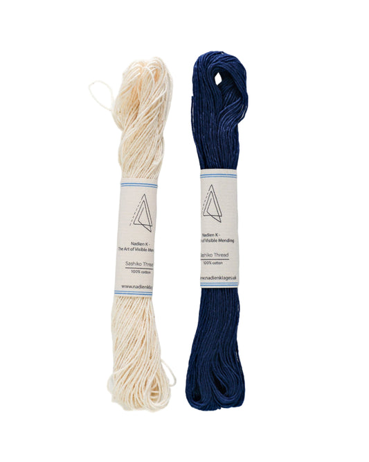 Two skeins of sashiko thread, one beige and one blue, on a white background.