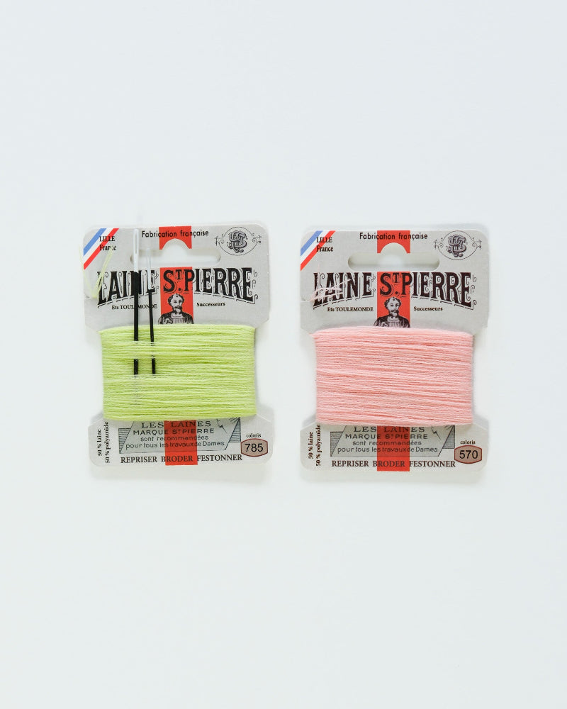 Two packages of Laine St. Pierre yarn, one green and one pink, on a white background.