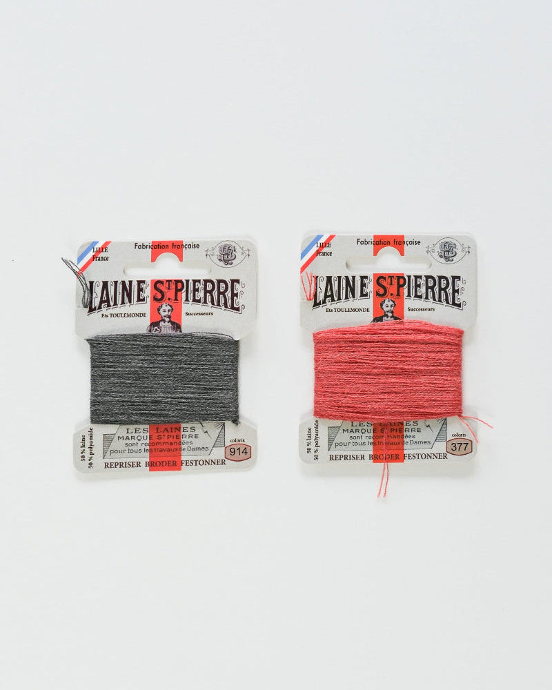 Two packages of Laine Spierre yarn, one grey and one coral, on a white background.