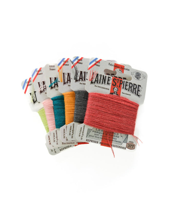 Set of colorful yarn skeins with labels on a white background