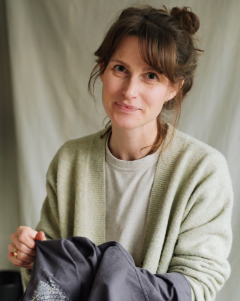 Woman holding a piece of fabric against a neutral background