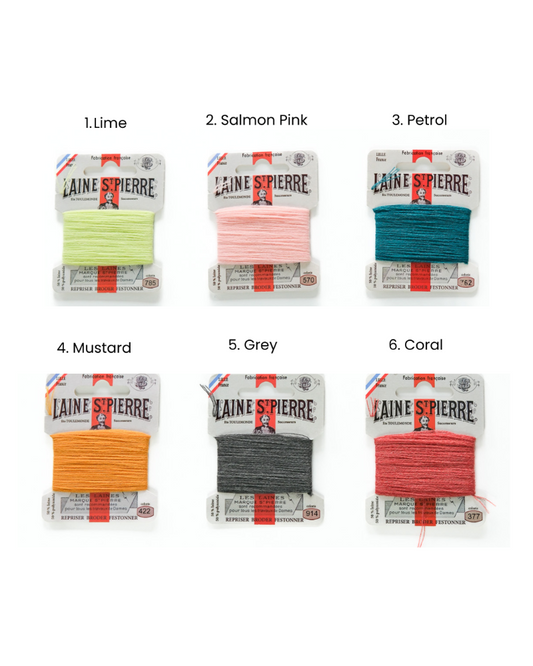 Set of six packages of Laine Pierre yarn in different colors on a white background