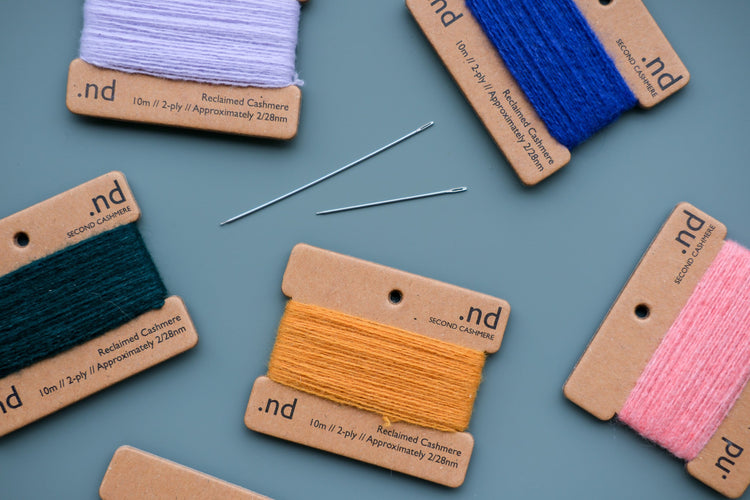 Selection of sewing tools laid out on a white background