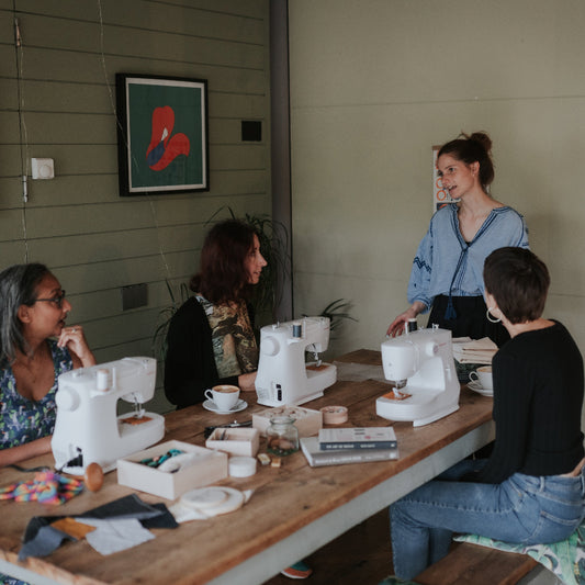 Group of people sitting around a table for a creative upcycling workshop
